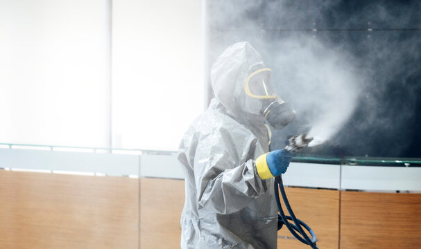 Cleaning staff desinfecting hospital against contageous virus, wearing protective clothing