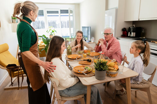 Happy family with grandparents eating a meal together at home
