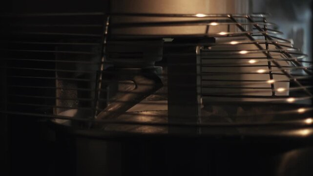Bread-making stage in private bakery. Dough undergoing kneading process by spiral mixer hook in modern bakery production. Dough kneading process in industrial-grade spiral Mixer.
