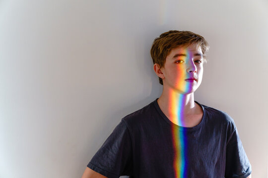 Boy with spectrum on face in front of wall