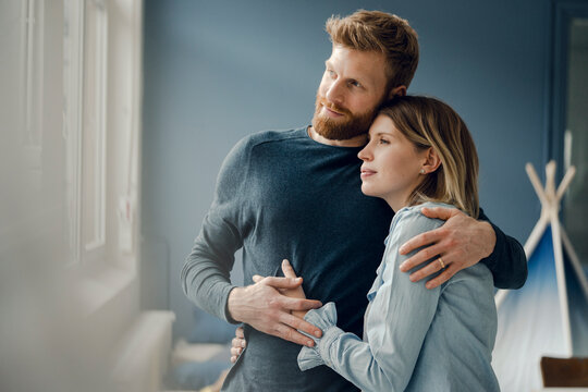 Happy couple embracing at home