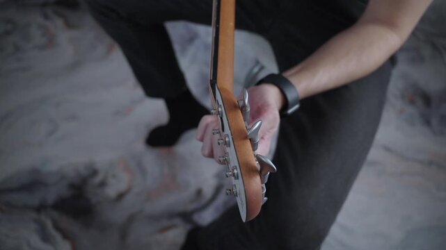 Top View of Tuning Acoustic Guitar with Tuning Pegs