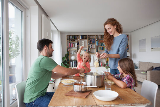 Couple with two children going to have lunch together at home