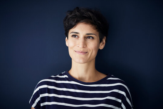 Portrait of smiling woman at blue wall