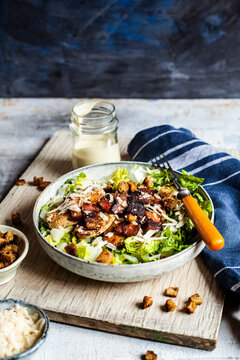 Bowl of Caesar salad with romaine lettuce, Parmesan cheese, bacon, chicken breast and croutons