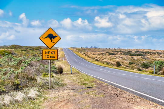 Kangaroo crossing sign by Great Ocean Road against sky, Victoria, Australia