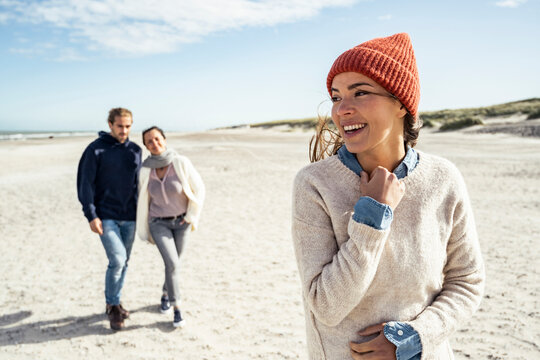 Portrait of woman wearing knit hat standing on beach