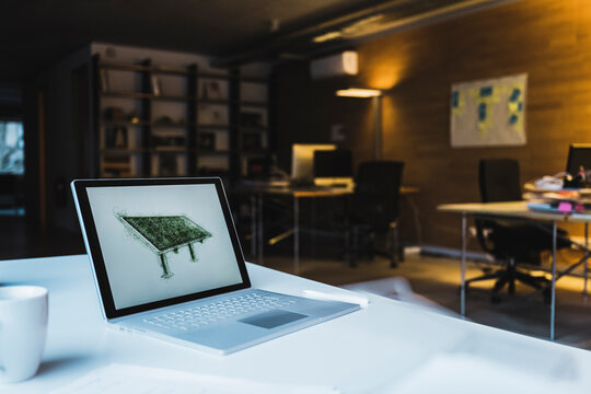Laptop with design of solar panel on screen in office