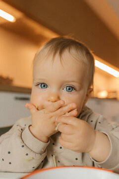 Portrait indoors learning self feeding with baby led weaning