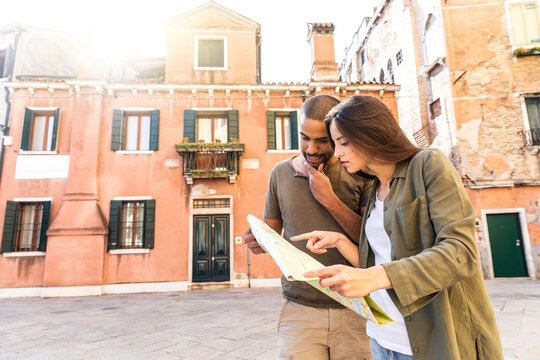 Italy, Venice, young couple looking at map in the city
