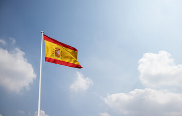 Spain flag waving in sky with long mast.