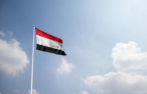 Yemen flag waving in sky with long mast.