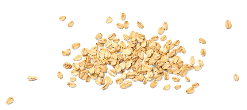 Scattered oat flakes on a clean white background.  Top view of oat flakes isolated.