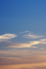 Fototapeta premium Dramatic sunset sky with yellow sunlight clouds on blue sky background in evening time