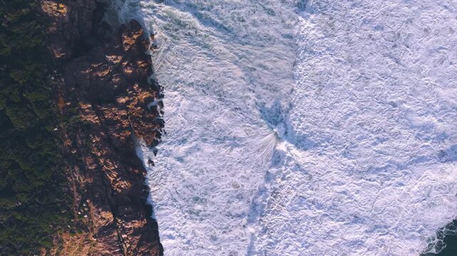 Aerial overhead waves breaking on the coastline