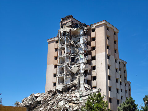 Building has collapsed in a city under clear blue sky during daylight hours