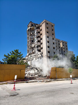 Building collapse at a construction site on a bright day with clear blue sky and nearby trees around