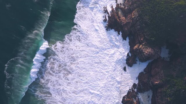 Aerial overhead waves breaking on the coastline