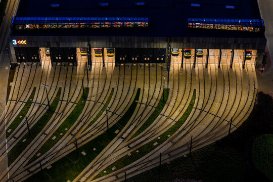 Aerial view of the Zajezdnia Annopol 01 tram depot featuring illuminated bays and intricate rail tracks converging into the facility at night in Warsaw, Masovian Voivodeship, Poland.