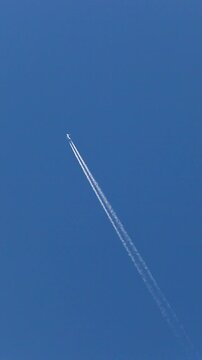 上昇する飛行機と飛行機雲
