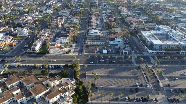 Coastal Urban Grid reveals structured layout of Huntington Beach neighborhoods where residential blocks meet Pacific parking zones. Morning light casts long shadows detailing density of CA city