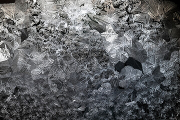 Ice crystals freezing on a black background, abstract winter photo surface © kichigin19