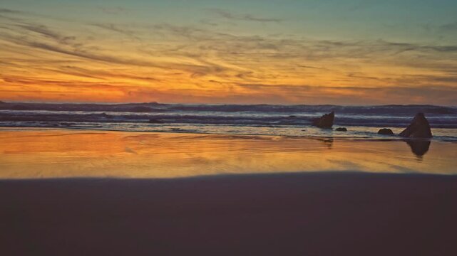 Reflejos del anochecer en la playa un dia de verano con tonos dominantes anaranjados, dorados  y azules que transmiten tranquilidad