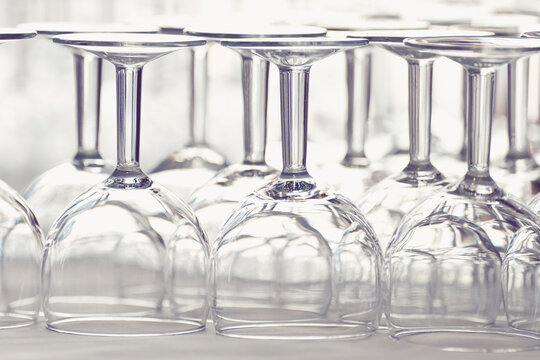 Close up of clear wine glasses upside down in rows