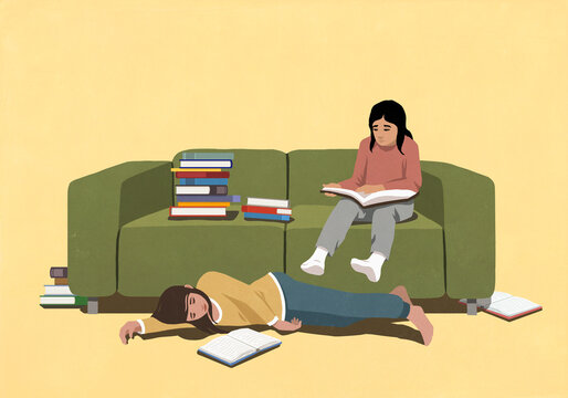 Girls studying, reading books at green sofa in living room