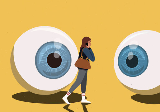 Large eyeballs watching woman on smart phone against yellow background