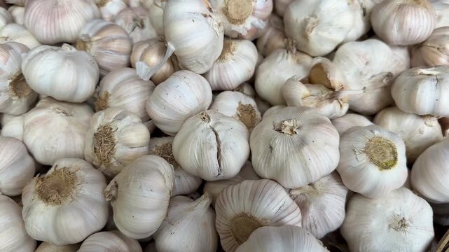 Full frame close up view of a large pile of fresh raw garlic bulbs in a market.