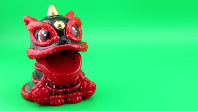 Seamless loop of a cute traditional Chinese lion dance toy nodding head and moving mouth on a green screen background. Ideal footage for chroma keying, Chinese New Year, and holiday projects