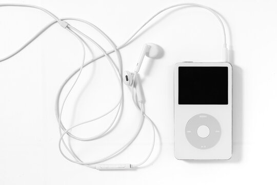Bangkok, Thailand - May 3, 2026: An iconic white Apple iPod Classic music player connected to original wired headphones on a plain white surface.