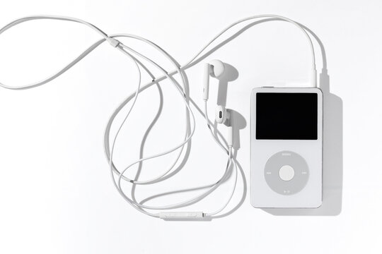 Bangkok, Thailand - May 3, 2026: An iconic white Apple iPod Classic music player connected to original wired headphones on a plain white surface.