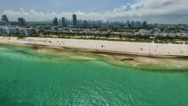 Aerial view of South Beach with turquoise ocean waters, sandy shoreline, and the Miami skyline in the background in Miami Beach, Florida, United States.