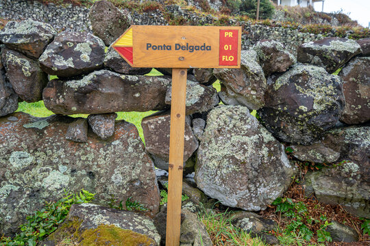Pedestrian trail direction sign for Ponta Delgada, Flores Island, Azores. Pedestrian trail sign leading to the Po&ccedil;o do Bacalhau waterfall, Ilha das Flores, Azores, Portugal.