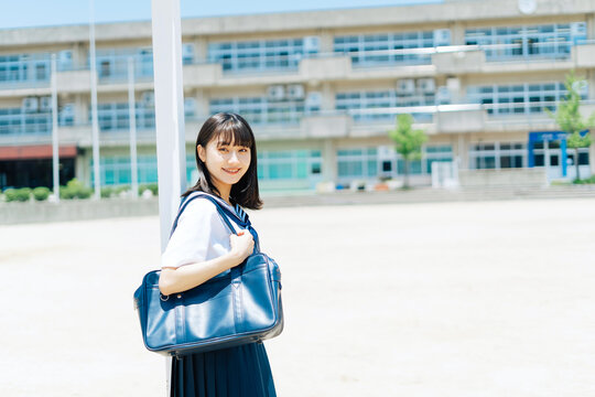 校庭のサッカーゴールにもたれる女子高校生