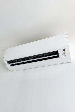 Split system air conditioner mounted on white wall, home cooling appliance.