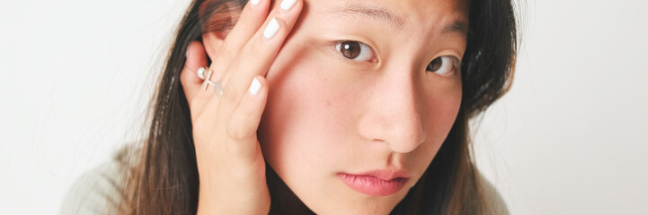 Fototapeta premium Close-up, girl in gray top looking at camera like at mirror isolated on white background, studio shot. Panoramic