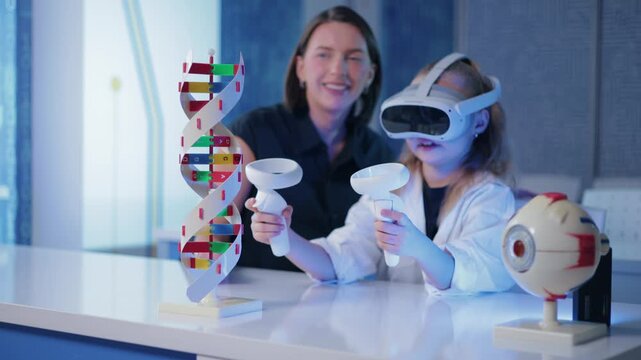 Kid girl using virtual reality controllers with teacher instructor at science lab table. Concept technology in education of school.