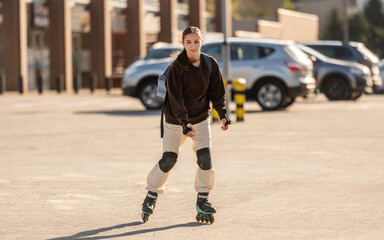 Fototapeta premium Happy Teen Girl Roller Skating In The Parking Lot