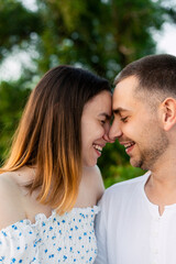 Fototapeta premium Young couple sharing a tender moment with noses touching and smiling outdoors