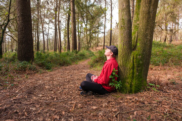 Fototapeta premium Man meditating in forest enjoying peace and nature