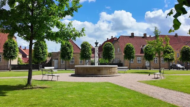Historic square near the Moravian Church in Christiansfeld with fountain, benches and traditional houses. Denmark