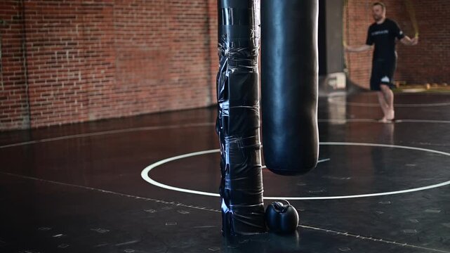 Dark lit gym boxing, martial arts, man working out, kickboxing, mat space, cinematic in silhouette bokeh background video, martial arts Wellnes theme