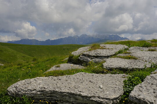 Mountain landscape in Malga Lessinia with limestone rocks and green hills