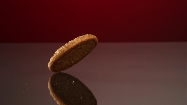 A single delicious cinnamon sugar snickerdoodle cookie slowly rotating on a dark reflective surface studio background video