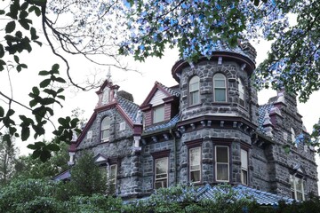 Abandoned Victorian mansion with turrets and overgrown garden © Iqra
