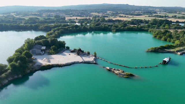 Aerial drone flying over a gravel pit lake and dredge