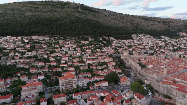 Dubrovnik old town orange red rooftops aerial below Srd hill at dusk